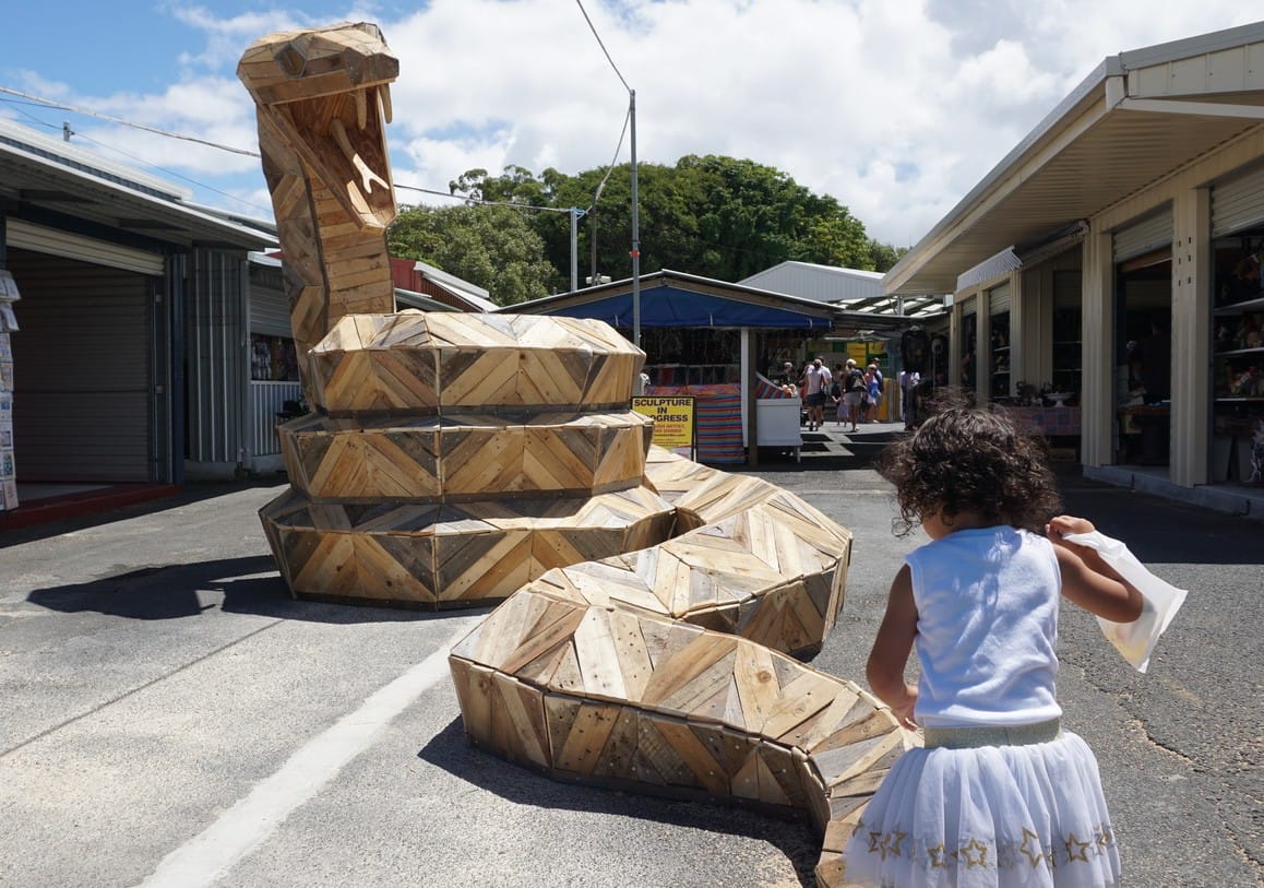 Large wooden snake sculpture by Thomas Dambo