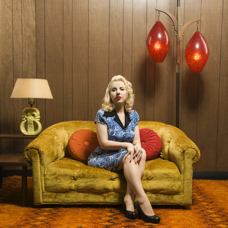 Woman sits in vintage decorated living room